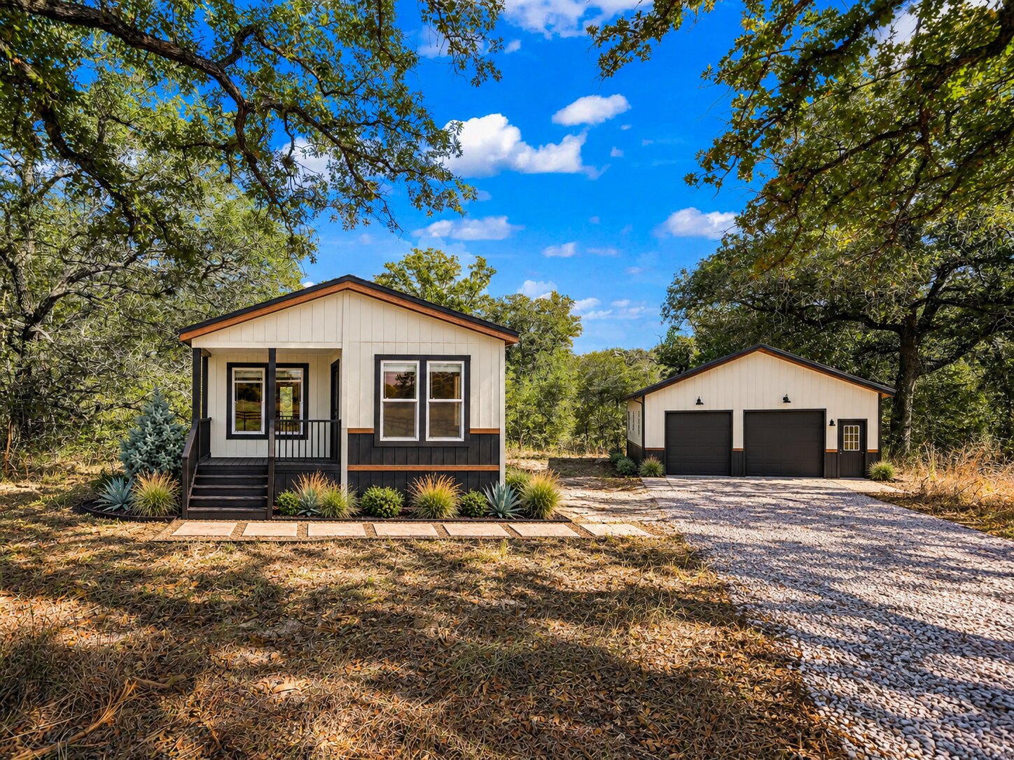 The same lot with a white factory-built home and detached two-car garage